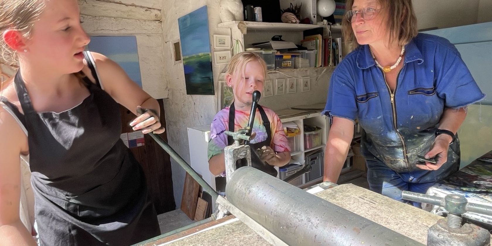 Kinder beim Drucken von Kaltnadelradierungen an der Tiefdruckpresse, &copy; Ute Laux
