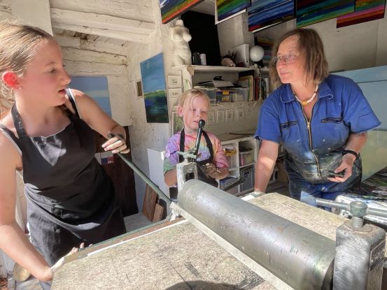 Kinder beim Drucken von Kaltnadelradierungen an der Tiefdruckpresse, &copy; Ute Laux